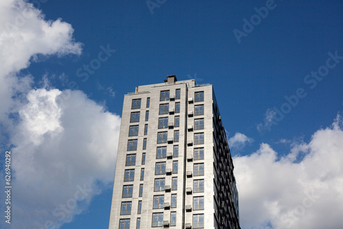 Multi-storey residential building against cloudy sky. New building on construction site