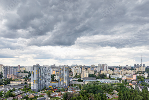 The city landscape, gray clouds over residential multi-storey buildings and parks covered the sky.
