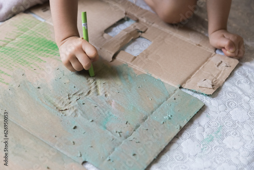 Sweet little girl playing with paints. Child exploring his creativity by drawing on the floor of his house.