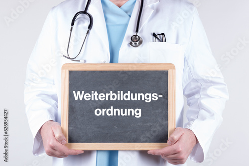Arzt mit einer Tafel auf der Weiterbildungsordnung steht