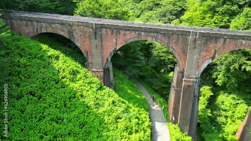 森の中を通る古い鉄橋、めがね橋の空撮｜An old iron bridge passing through the forest. Aerial view of Meganebashi Bridge photo