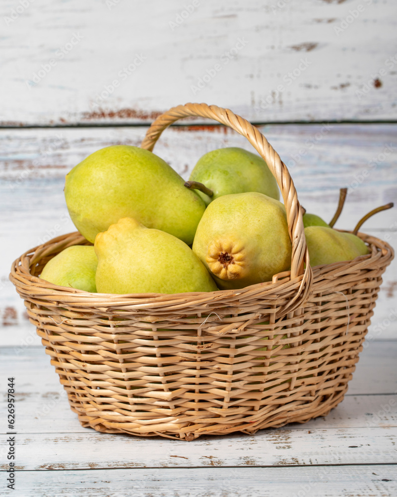 Fresh pears in a wicker basket over wooden background. Pear harvest season concept. Healthy and fresh fruit. Close up Fresh pears in a wicker basket over wooden background. Pear harvest season concept. Healthy and fresh fruit. Close up