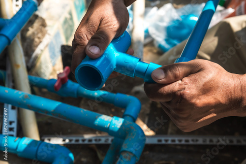 Close up plumber hands with water supply pipe installation