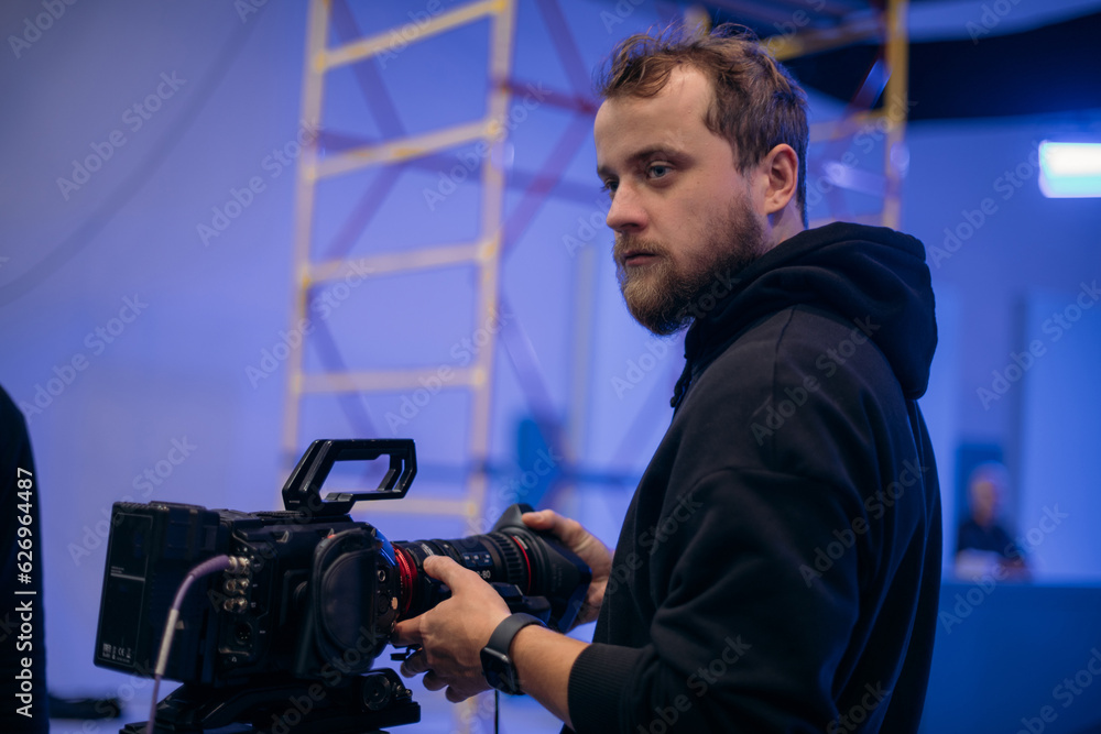 Director of photography with a camera in his hands on the set. Professional videographer at work on filming a movie Director of photography with a camera in his hands on the set. Professional videographer at work on filming a movie