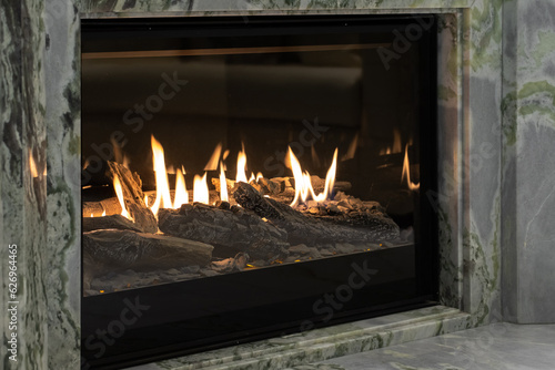 Burning gas fireplace built into marble photo