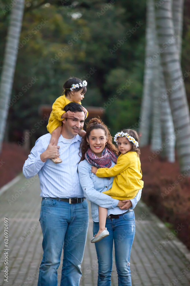 Family of four having fun outdoors in a beautiful sunny day at the park. Happiness concept. Family concept. Family of four having fun outdoors in a beautiful sunny day at the park. Happiness concept. Family concept.