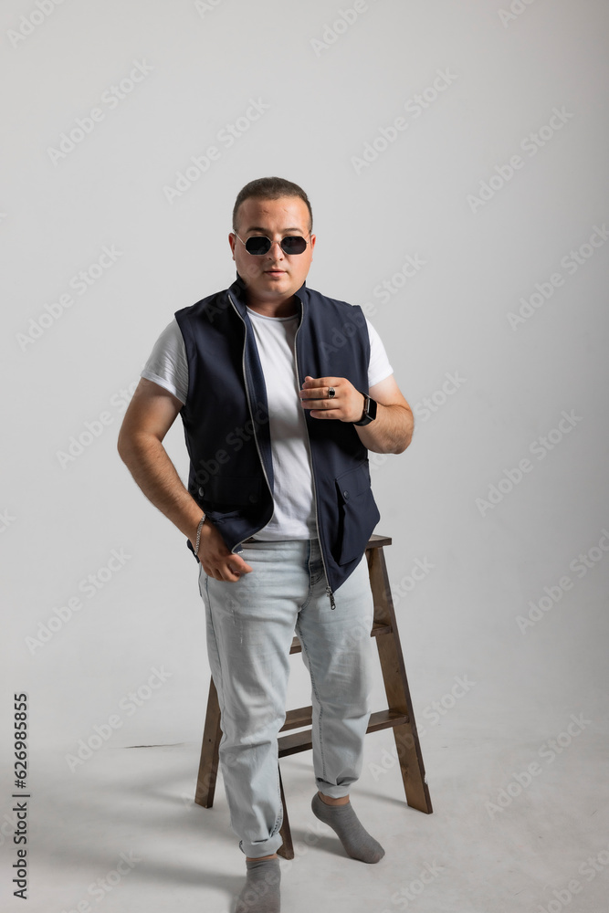 A cheerful young man model in a sleeveless regular solid jacket and a black sunglass posing in multiple different styles over white background with dimensions of width 5464 p and height 8192 p
A cheerful young man model in a sleeveless regular solid jacket and a black sunglass posing in multiple different styles over white background with dimensions of width 5464 p and height 8192 p