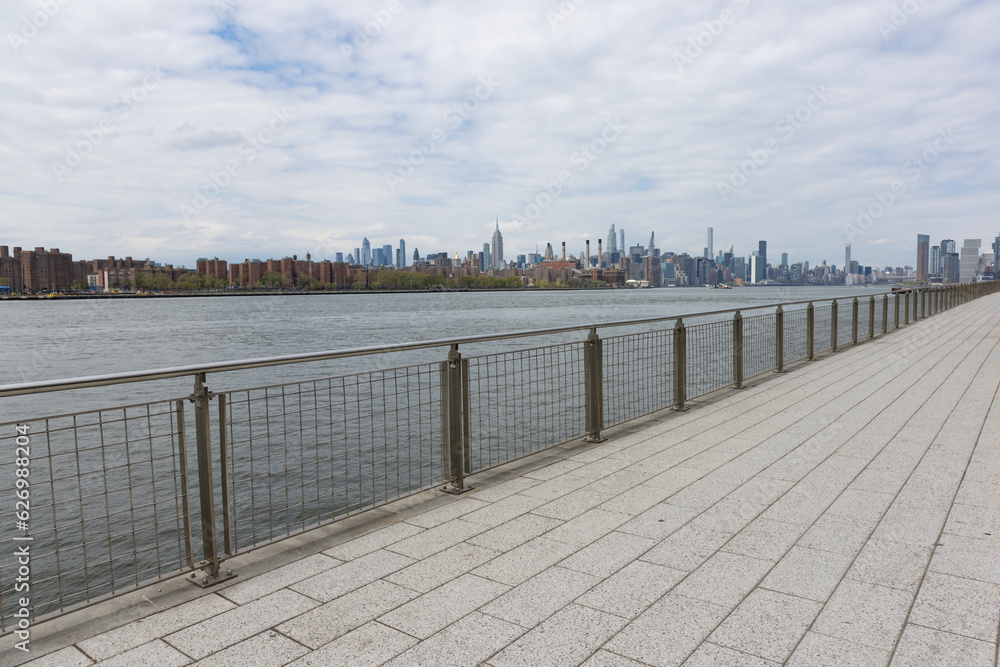 Empty Walkway along the East River at Domino Park with a View of the Manhattan Skyline in Williamsburg Brooklyn