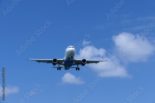 Airplane in the blue sky with white clouds, travel concept.