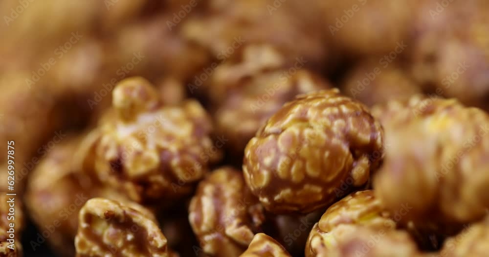 pour delicious sweet popcorn with lots of caramel, caramel flavor of popcorn close-up pour delicious sweet popcorn with lots of caramel, caramel flavor of popcorn close-up