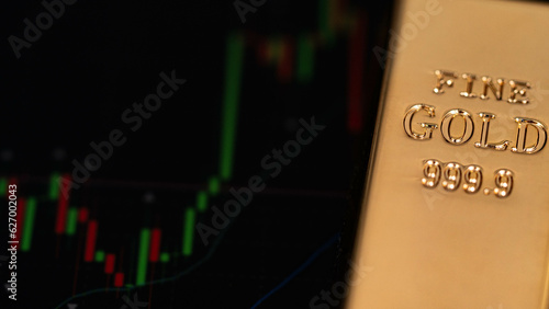 gold bars place on the phone that opens the candlestick chart. Fluctuations in gold prices concept.