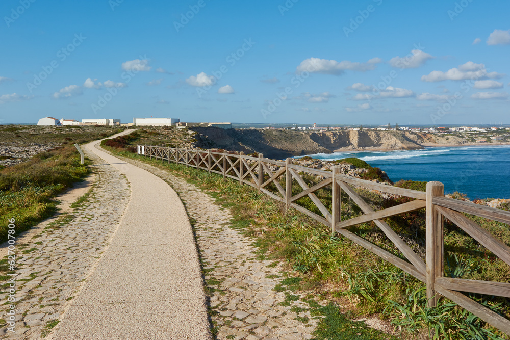 View of the Sagres Fortress and Sagres village in Portugal. Wooden fence and walkway in the foreground