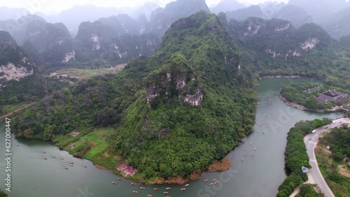 Rivière et bateaux dans ces paysages montagneux au Vietnam en Asie du Sud-Est - Nature et culture dans une région surnommée la baie d’Halong terrestre.