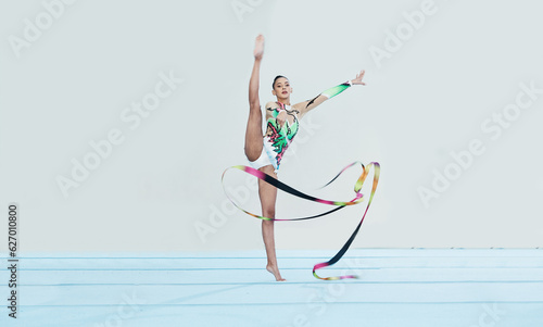 Gymnastics training, woman and ribbon with legs split for competition, sport and balance in portrait. Gymnast, athlete girl or professional dancer for concert, performance and contest with creativity