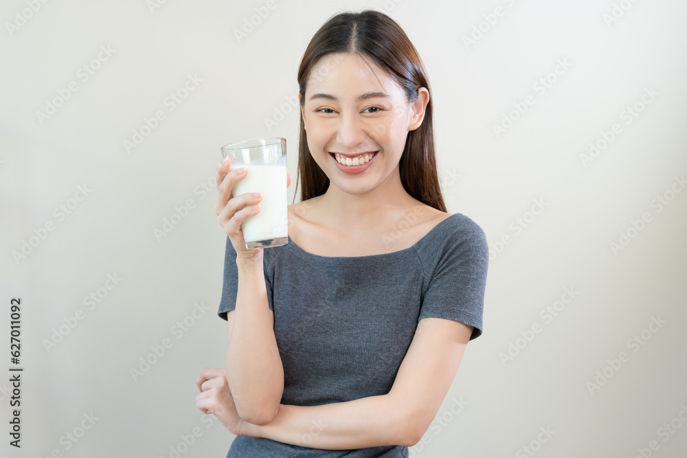 Happy, asian young woman, girl drinking a glass of white fresh, warm or hot dairy milk for calcium, vitamin wholesome good nutrition in morning. lifestyle, product healthy people, Isolated background. Happy, asian young woman, girl drinking a glass of white fresh, warm or hot dairy milk for calcium, vitamin wholesome good nutrition in morning. lifestyle, product healthy people, Isolated background.