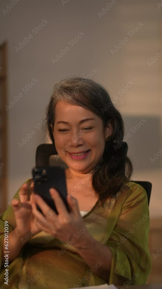 Relaxed senior woman using smartphone for online social media. Relaxed senior woman using smartphone for online social media.