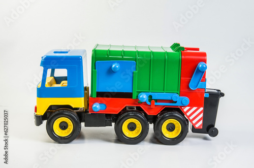 Multi-colored plastic toy trucks for children's games on a white background. Garbage truck. © baxys