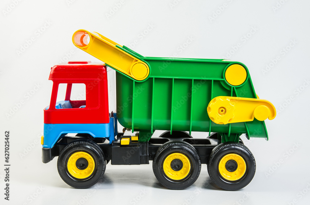 Multi-colored plastic toy trucks for children's games on a white background. Dumper.