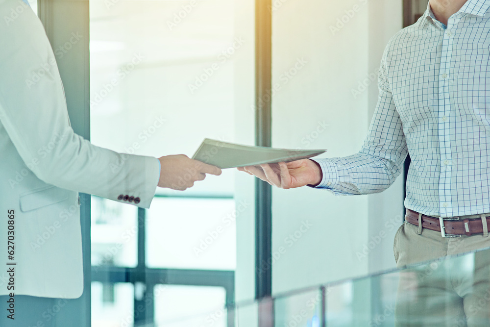 Doing a handover. Shot of a businessman handing a document to a colleague.
