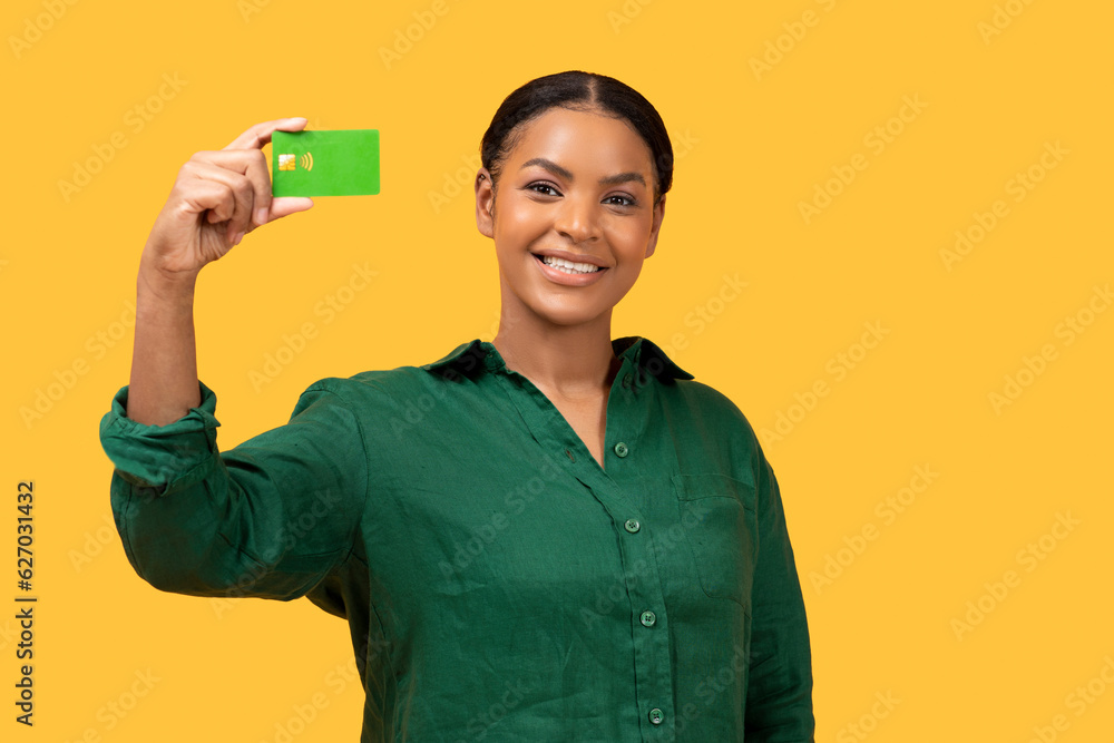 Black Woman In Casual Showing Bankcard Posing Over Yellow Background Black Woman In Casual Showing Bankcard Posing Over Yellow Background