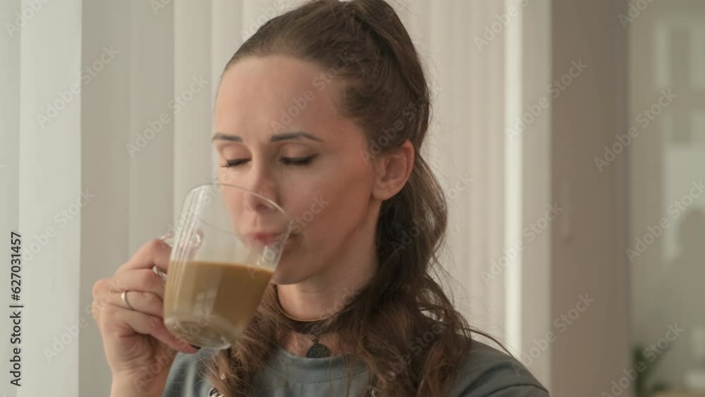 Medium close up of young craftswoman enjoying cup of coffee in her own leather workshop Medium close up of young craftswoman enjoying cup of coffee in her own leather workshop