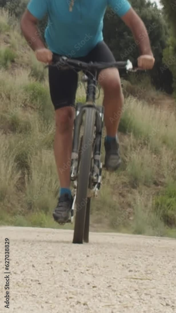 Vertical video. Mountain biker man on a dirt road during a competition Vertical video. Mountain biker man on a dirt road during a competition