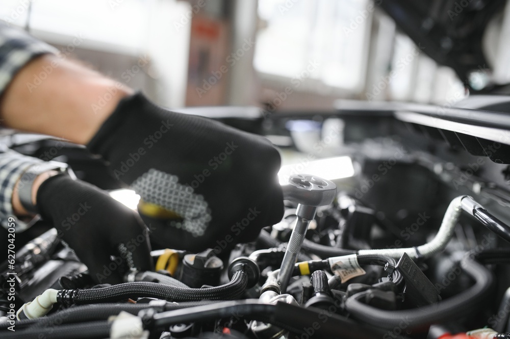 Professional Mechanic is Working on a Car in a Car Service. Professional Mechanic is Working on a Car in a Car Service.