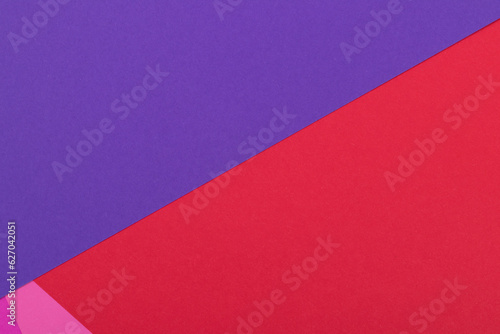Multicolor background from a paper of different colors. Mix of pink, red and purple colors. Geometric backdrop.