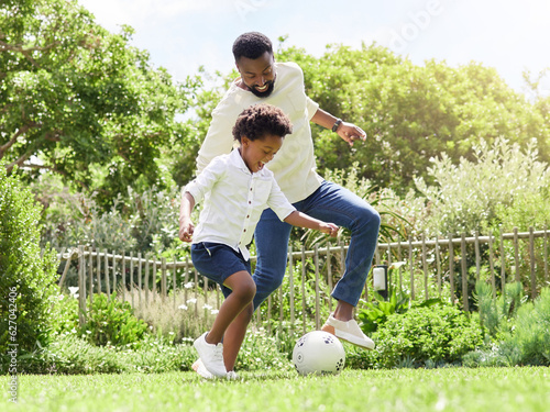 Soccer, happy dad and kid on a garden with exercise, sport learning and goal kick together. Lawn, fun game and black family with football on grass with youth, sports development and bonding on field