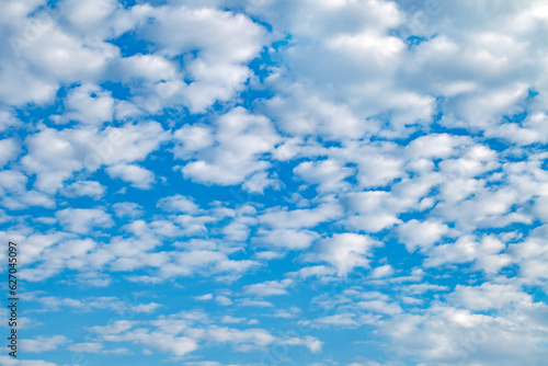 Layered cumulus clouds in blue sky on clear day, background