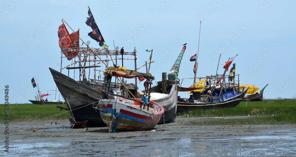 Fishing boats are waiting for the tide.So the fishermen are repairing the nets sitting in boat.Fishermen will go to the sea and catch the popular fish Hilsa. Fishing boats are waiting for the tide.So the fishermen are repairing the nets sitting in boat.Fishermen will go to the sea and catch the popular fish Hilsa.