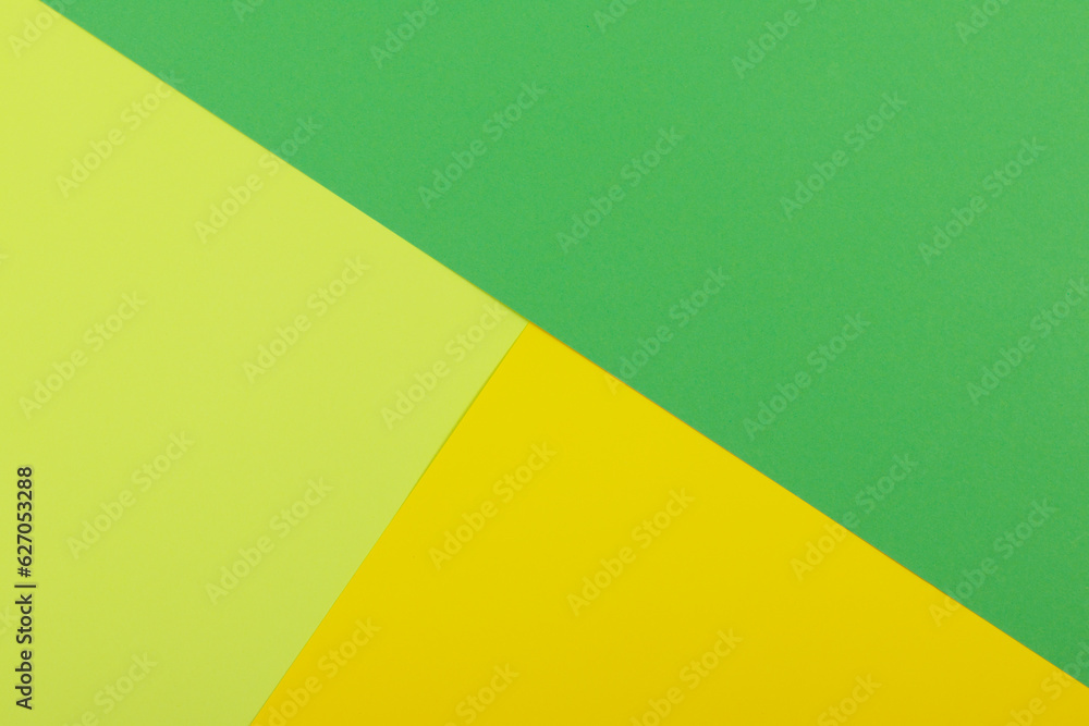 Multicolor background from a paper of different colors. Mix of yellow, green and lime colors. Geometric backdrop.