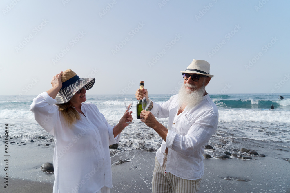 lifestyle of caucasian senior couple drinking champagne on beach, happy in love romantic and relax time, tourism of elderly family pleople, leisure and activity travel after retirement