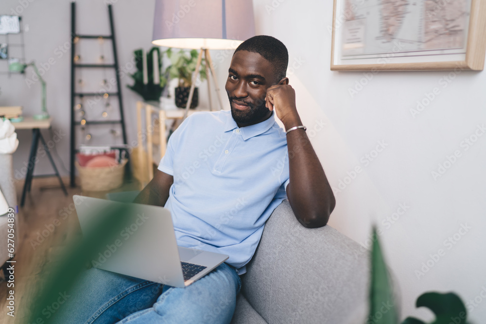 Fototapeta premium Happy black man working on netbook at home