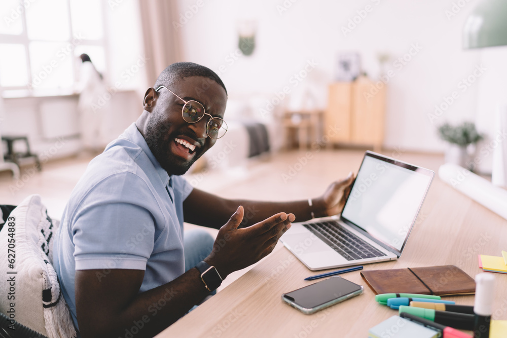 Happy black man working on netbook at home Happy black man working on netbook at home