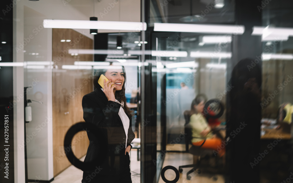 Happy woman talking on cellphone in modern workspace Happy woman talking on cellphone in modern workspace