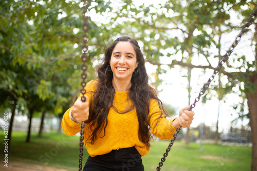 smiling young woman swinging in the park