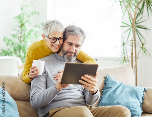 woman couple senior man happy internet love tablet together mature active elderly retirement computer technology online using caucasian home adult family romance photo