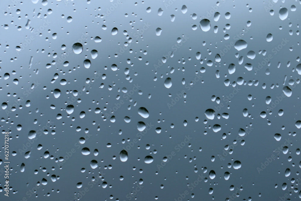 Rain drops on the surface of a window glass in a rainy day