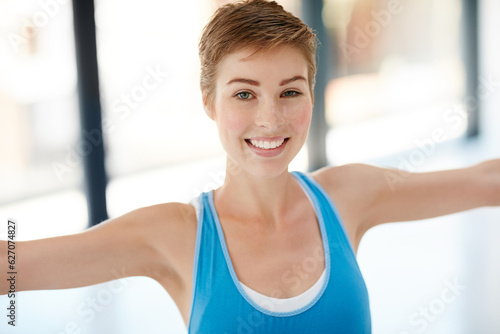 Woman, portrait smile and stretching in yoga for healthy fitness or spiritual wellness and zen workout indoors. Happy female yogi in warm stretch smiling in happiness for exercise or balance at gym