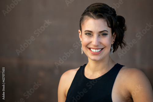 Friendly and warm portrait of a stylish young woman with a big natural smile, excited and happy person