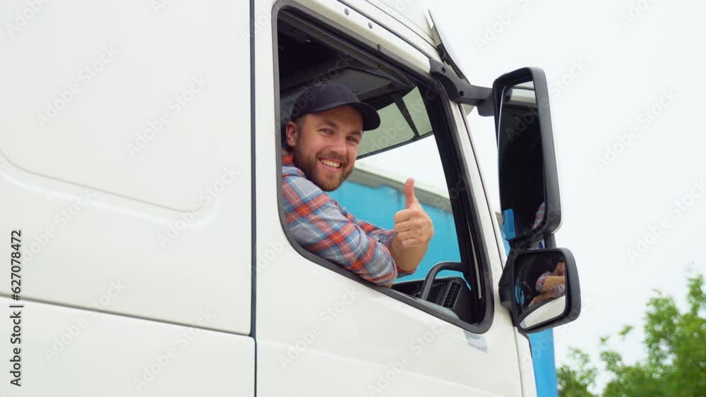Truck driver sitting in his truck showing thumbs up. Trucker occupation. Transportation services. Right hand drive car Truck driver sitting in his truck showing thumbs up. Trucker occupation. Transportation services. Right hand drive car