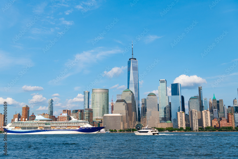 Obraz premium Cruise ship sailing next Manhattan in New York. Skyline of New York Manhattan cruising on the Hudson River cruise liner . Vacation on cruise liner.