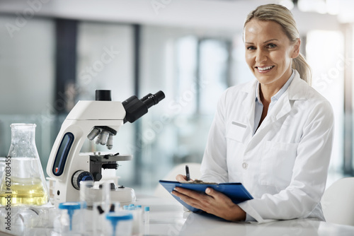 Im here to cure. Cropped portrait of an attractive mature female scientist taking down notes while doing research in her lab.