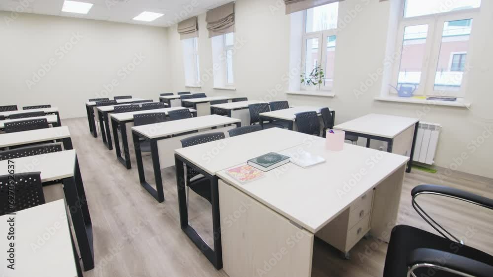 Newly redecorated auditorium with comfortable black chairs and modern white desks. Modern lecturer working place with orthopedic armchair Newly redecorated auditorium with comfortable black chairs and modern white desks. Modern lecturer working place with orthopedic armchair