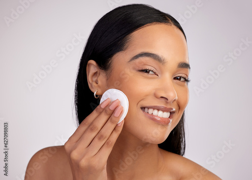 Quadro su tela Happy woman, cotton pad and cleaning face in skincare for makeup removal against a grey studio background