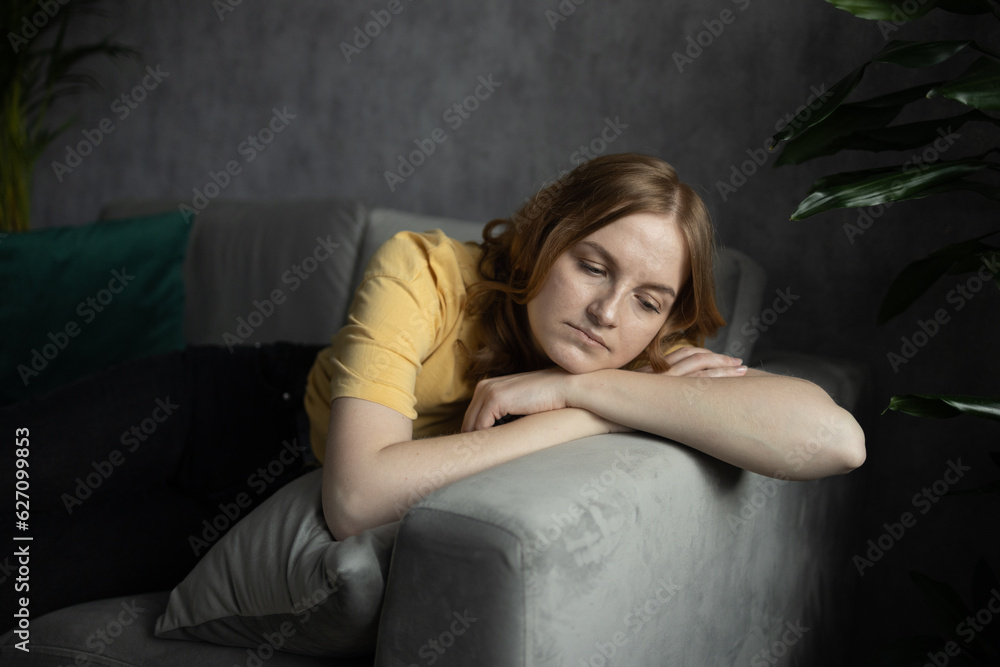 Tired upset 30s blonde woman worried about tiredness from domestic work sitting at couch. Frustrating mom stressful feels heaviness and headache at home. Fatigue parent trying relaxing in living room Tired upset 30s blonde woman worried about tiredness from domestic work sitting at couch. Frustrating mom stressful feels heaviness and headache at home. Fatigue parent trying relaxing in living room