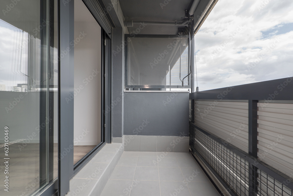 Terrace of a house with a gray fabric roller awning Terrace of a house with a gray fabric roller awning