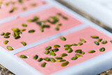 Closeup shot of handmade ruby chocolate with pistachios. Delicious ruby chocolate in bar moulds. Chocolate manufacture concept. High quality photo