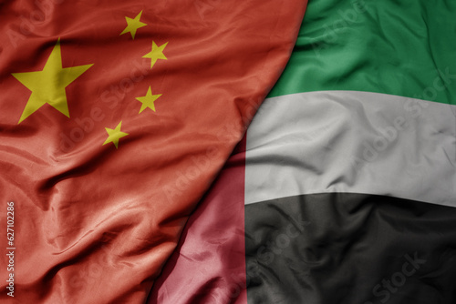 Photography big waving national colorful flag of china and national flag of united arab emirates